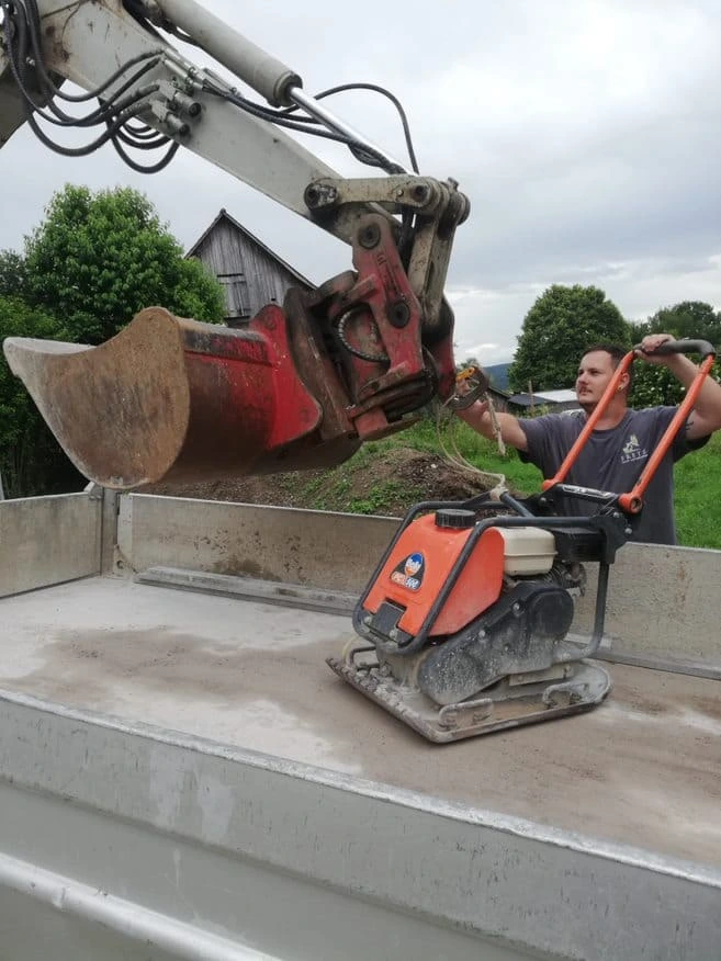 Präzisionsarbeit im Gartenbau Winterthur – Gärtner befestigt Maschine am Baggerarm